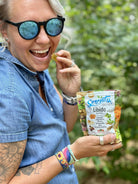 A woman enjoying a Serenity CBD's Libido Gummy - Organic herbal gummies designed to boost energy and enhance vitality.