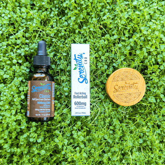 Serenity CBD Classic Full Spectrum Tincture, Fast Acting 600mg Rollerball, and a bamboo-lid jar arranged on fresh green grass—symbolizing natural relief, balance, and plant-powered wellness