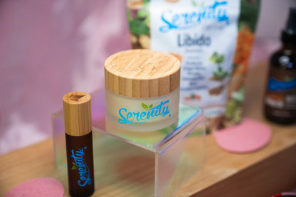 Serenity skincare products including a jar and roller bottle on a wooden surface.