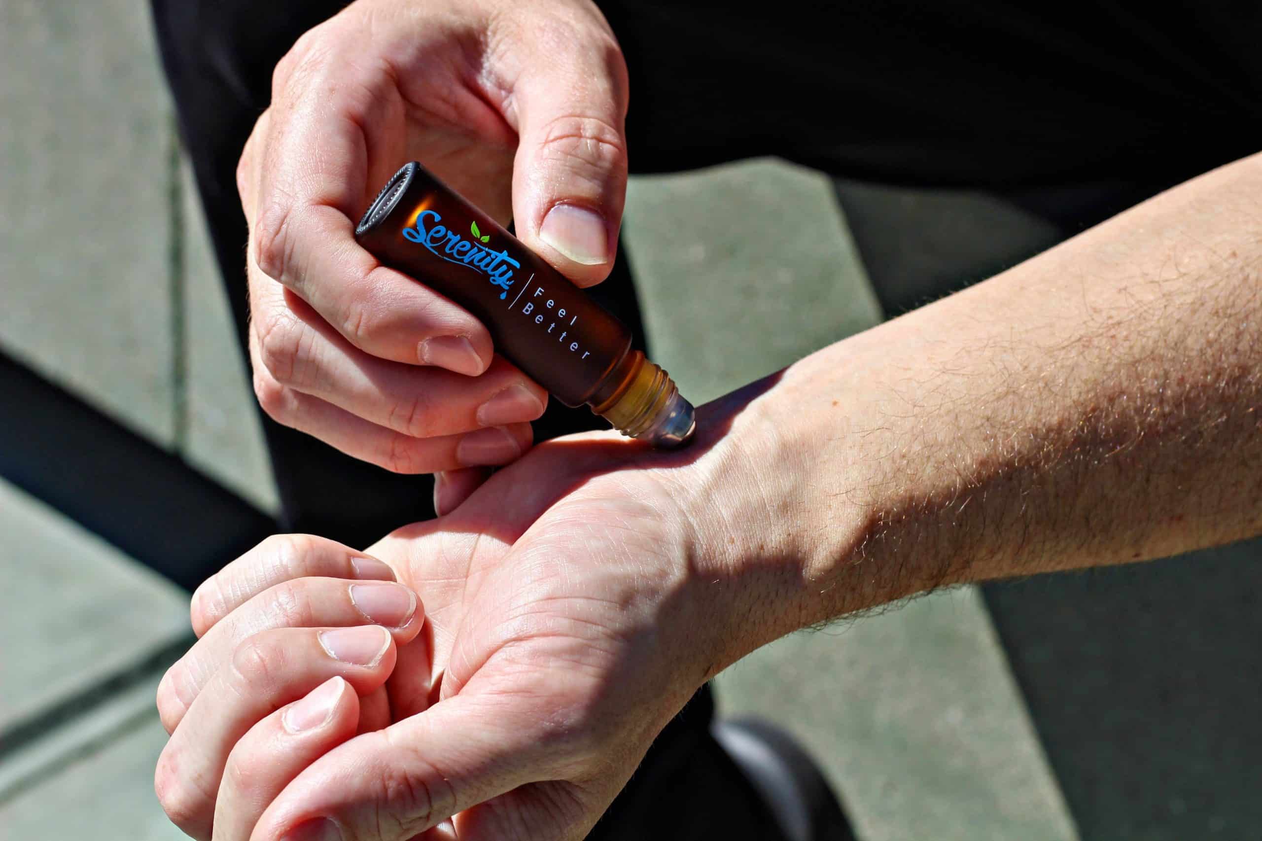 A man applying Serenity CBD’s Classic Roller on her arm - Organic, full-spectrum CBD roll-on for quick relief and muscle relaxation.