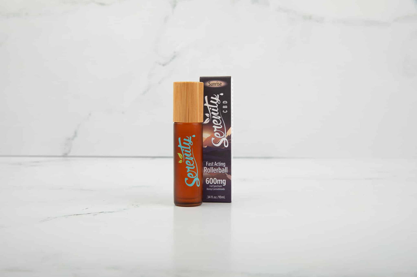 Serenity CBD Sunrise Blend Roller with packaging on a clean marble surface—crafted for energizing relief and uplifting wellness support