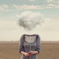 An illustration representing brain fog shows a woman's body with a cloud of fog covering her head.