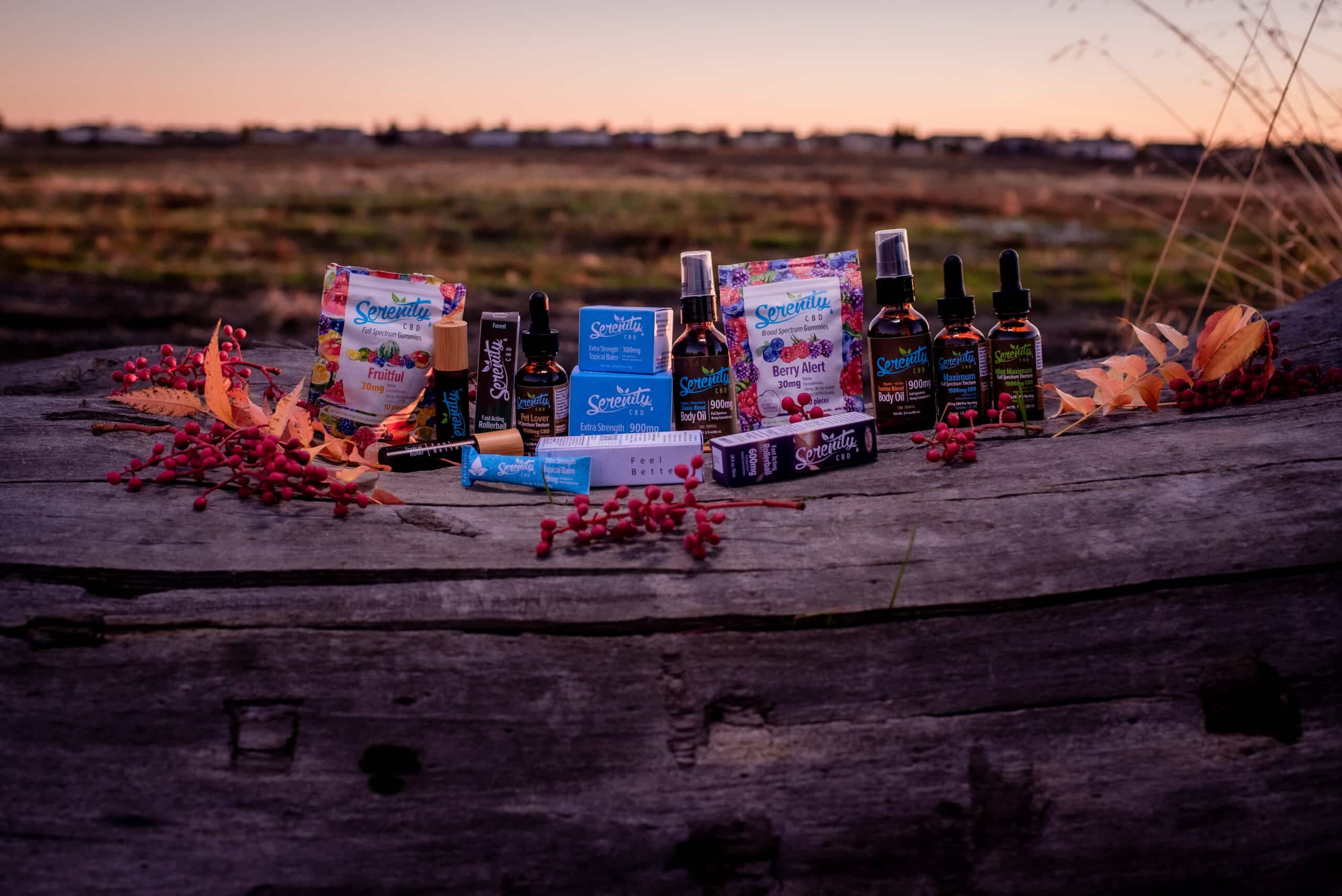 Serenity CBD products on a log with beuatiful sunrise backdrop
