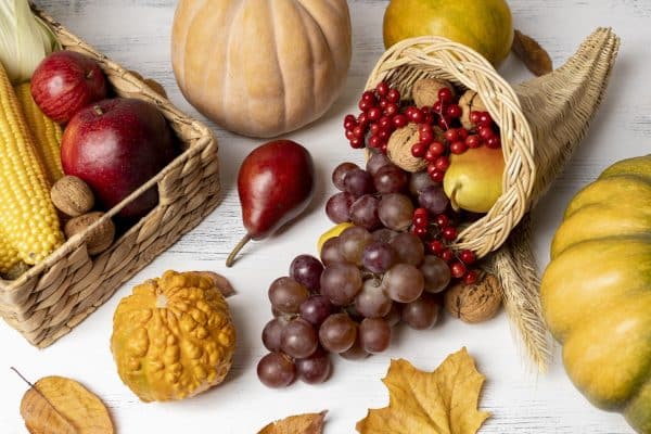 Assorted fresh autumn fruits and vegetables like pumpkins, apples, and root vegetables, highlighting seasonal produce for Ayurvedic nutrition and fall wellness.